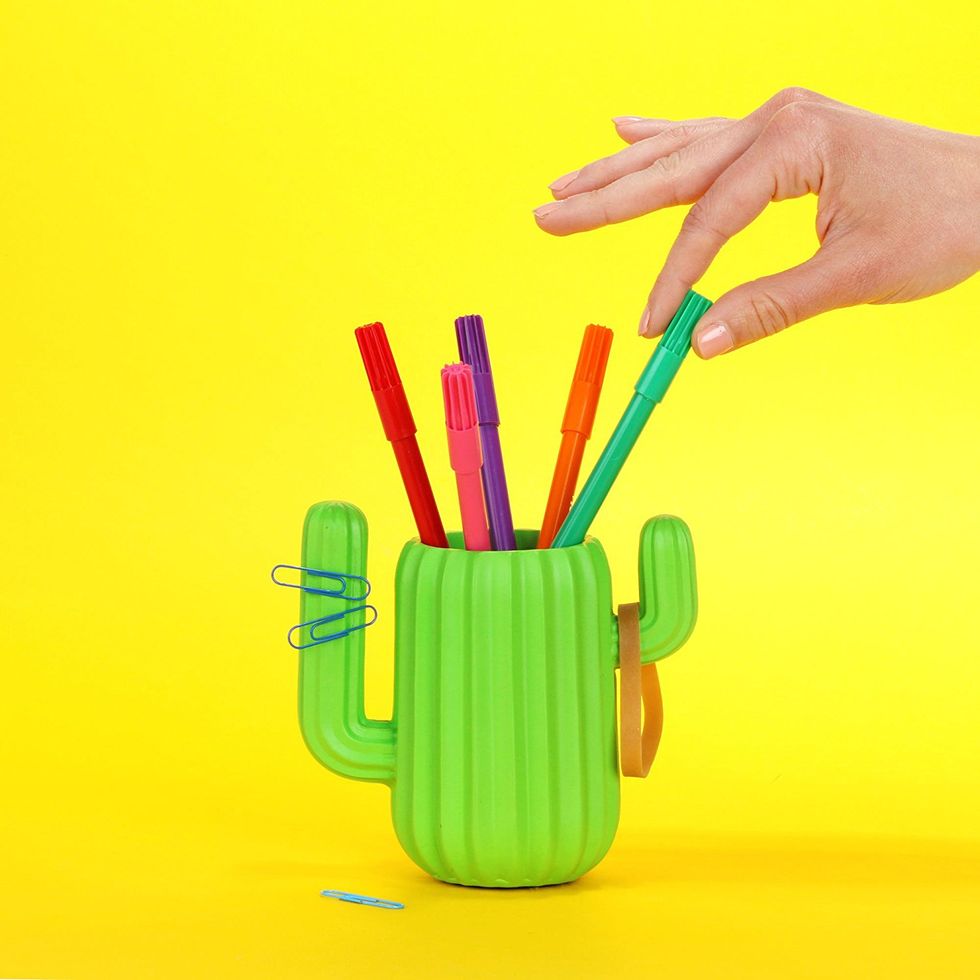 A cup shaped like a cactus with five pens inside.