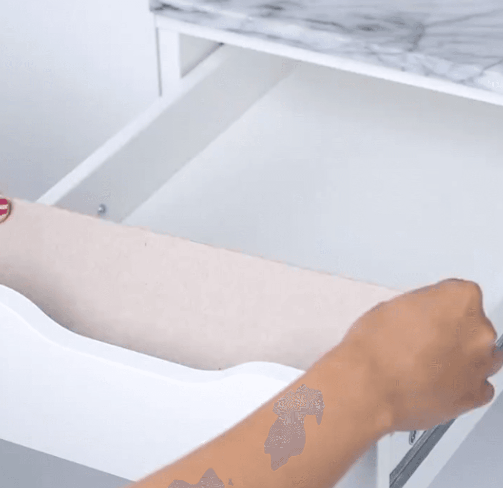 A woman places a small ramp into a drawer